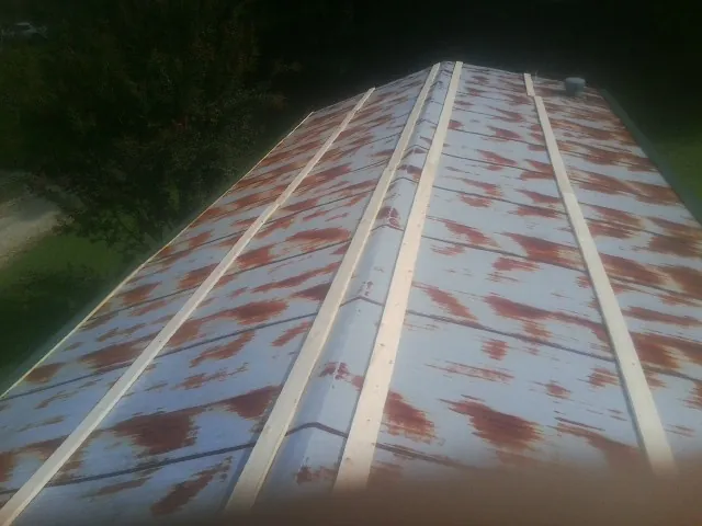 Rusted metal roof panels with new wood purlins before replacement — Storm Damage Roof Repair in Gilson by Roofing Brothers