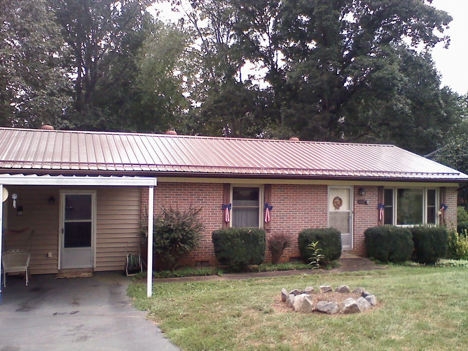Bronze metal roof and carport on a brick ranch home — Roof Repair work by our crew in Gilson
