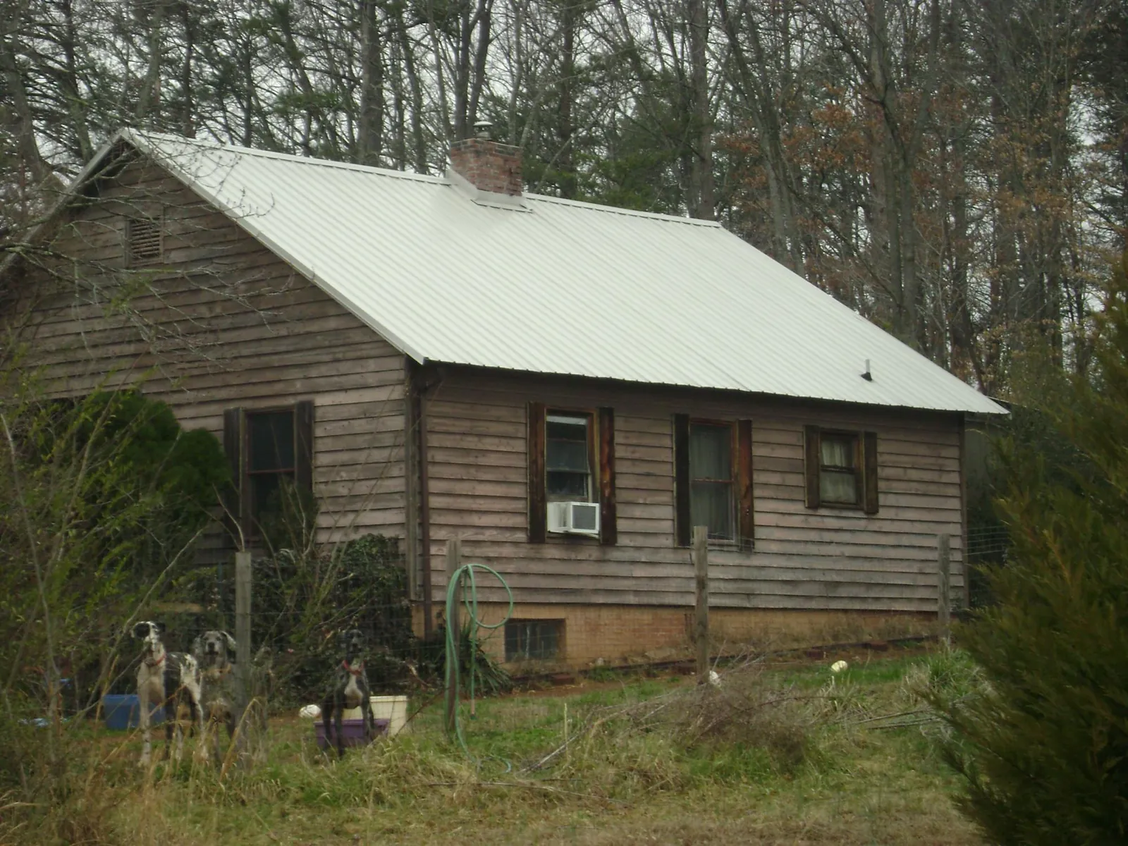 White metal roof on an old wood sided farmhouse, from a Metal Roof Installation job in Gilson